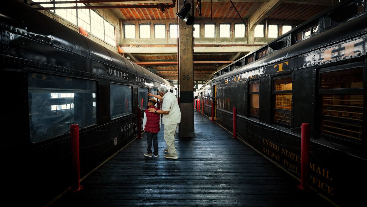 Man and child observing an old train at the N.C. Transportation Museum 